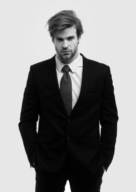 Resmi takım elbiseli, elleri cebinde beyaz arka planda yalnız bir adam. Beyaz arka planda izole edilmiş ciddi genç iş adamının portresi.