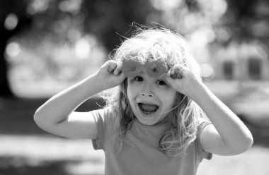 Çiçek açan yaz bahçesinde çiçek toplayan sevimli küçük bir çocuk. Bahar çocuğu suratı. Yazın çimlerin üzerinde çiçeklerle mutlu küçük bir çocuk. Bahçedeki çayırda küçük şirin bir çocuk.