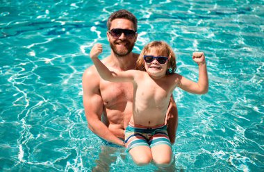 Yüzme havuzunda bir aile. Baba ve oğul yaz tatilinde. Havuz partisi. Babası yüzme havuzunda oynayan bir çocuk.