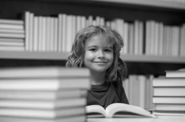 子供は図書館で本を読む 学校の図書館で本を持つ少年 読書のための文学 子供は本から学ぶ 学校教育と賢い才能のある生徒の天才 — ストック写真