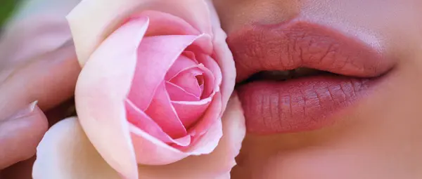 唇とバラ 春のバナーを閉じます 唇から自然塗料 美しいモデルの女の子の口の中に官能的な唇 美容メイクが閉じます 春の花 — ストック写真