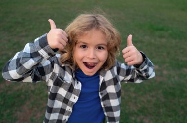 Dışarıdaki çocuğun portresi. Kapalı yüzlü çocuk yaz parkında dışarıda oynuyor.