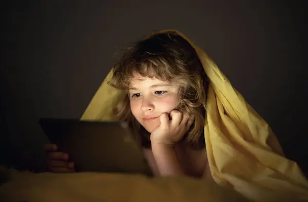 Enfant Regardant Tablette Avant Dormir Enfant Lit Book Petit Garçon Image En Vente