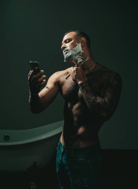 Tıraş kremi. Kuaför makası ve ustura. Berber ve Kuaför Salonu hakkında fikir. Vintage kuaför dükkanı tıraş. Kuaför saç modeli bir sakallı bir adam yapar.