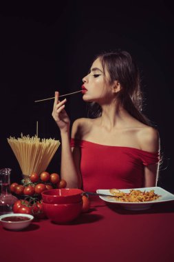 Sexy kitchen. Sexy Woman in the kitchen cooking Pasta. Italian Pasta concept. Homestyle pasta love. Noodles or spaghetti. Sensual woman eating spaghetti. Photo Image of a Beautiful Woman Eating Pasta clipart