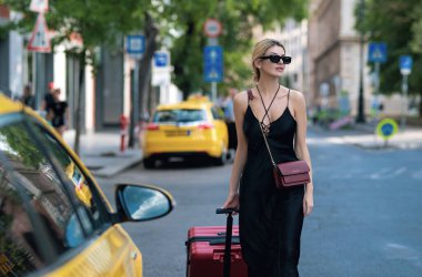 Sokakta yürüyen güzel sarışın kızın portresi. Moda kıyafetleri içinde genç bir hippi kadın. Moda sokağı. Sokakta poz veren kaygısız seksi kadın. Güneş gözlüklü sarışın kadın. Sokak tarzı