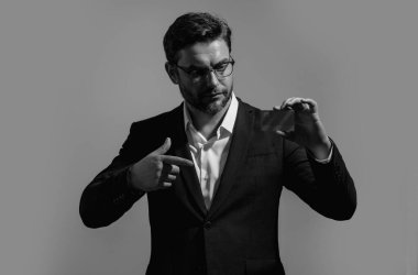 Kredi kartı konsepti. Beyaz ırkın başarılı 40 'lı yılların iş adamı, bankacılık kartını gri arka planda, stüdyo portresi üzerinde izole bir şekilde tutuyor. İnsanların yaşam tarzı konsepti. Satın alma ve geri ödeme ödülleri