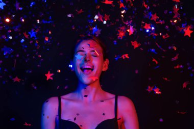 Konfeti üfleyen seksi kız. Sevgililer gününde güzel bir genç bayanın portresi. Seksi kadın güzellik mankeni doğum gününde ışıldıyor. Doğum gününü kutlayan şehvetli kadın. İyi ki doğdun