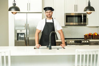 Yemek pişirme ve aşçılık konsepti. Mutfakta üniformalı aşçı. Erkek aşçı ya da önlüklü aşçı. Aşçının bereli portresi. Yemek pişirme konsepti