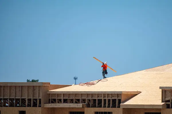 Roofer carpenter working on roof structure on construction site. Roofer on roofing job. Roof on high work place. Workers on construction sites roofing. Roofing work. Roofing tools for wooden roofs