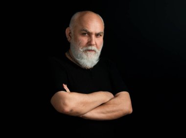 Sakallı, orta yaşlı, ciddi bir yüz ifadesi olan, yakın plan bir kafa ve omuz portresi olan adam.