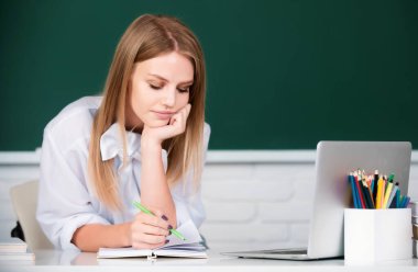 Lisede ya da üniversitede ders veren kız öğrenci. Öğrenci eğitimi konsepti. Üniversitede ödev yapmayı düşünen kız öğrenci.