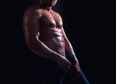 Kaslı, üstsüz, erkek modeli, karın kası gösteriyor. Gay seksi model. Mükemmel karın kaslarına yaklaş. Altılı paketli güçlü bir vücut geliştirici. Karın kasları, kol ve göğüs kasları. Adam kaslarını kasıyor.