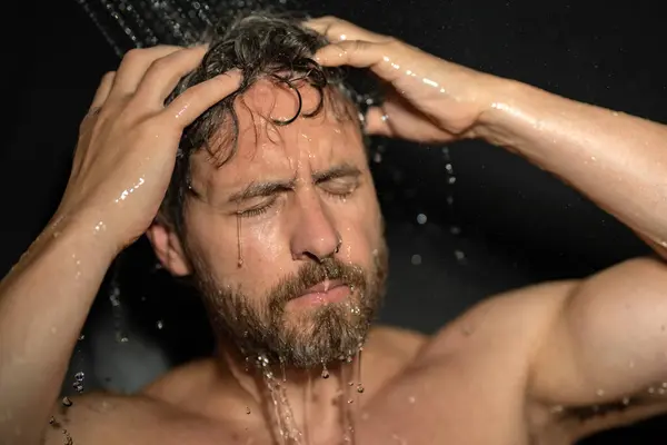 Portrait of man washing hair with shampoo taking shower. Washing hair with shampoo. Man washing hair with anti-dandruff shampoo, taking a shower. Hair care product, foam gel, shampoo and lotion