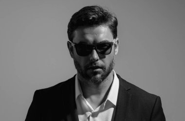 Gri stüdyodaki iş adamı izole edilmiş. Takım elbiseli zengin adam, stüdyo portresi. Başarılı bir iş adamı. Finansal başarı. İş adamı başarılı anlaşma