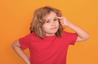 Stüdyonun izole edilmiş geçmişini düşünen ciddi bir çocuk. Düşün ve düşün. Düşünceli çocuk stüdyo resmi. Şüpheci ve endişeli çocukların ifadesi