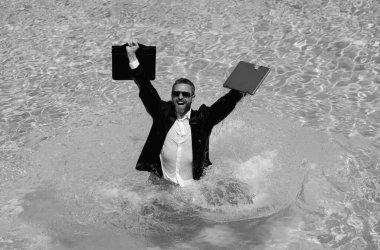 Seyahat yerleri, ofis çalışanlarına yaz tatilleri. Yaz tatilinde deniz kıyısında takım elbiseli komik bir iş adamı. Çılgın girişimci yaz tatilinde yüzme havuzunda dizüstü bilgisayar kullanıyor.