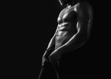 Güçlü omuzları var. Kaslı, üstsüz, erkek modeli, karın kası gösteriyor. Gay seksi model.