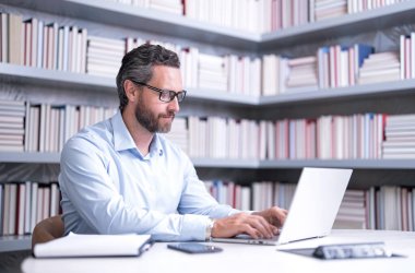 Kütüphanedeki İspanyol iş adamının portresi. Ofisteki yakışıklı iş adamı. İşadamı ders veriyor. Ofis işleri.