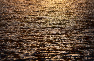 Altın dramatik gökyüzü manzaralı deniz üzerinde gün batımı. Gün batımı gökyüzü olan sakin bir deniz. Okyanus ve gökyüzü arkaplanı