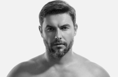 Kırklı yaşlarda yarı çıplak bir adamın portresi beyaz arka planda izole edilmiş. Yakışıklı, ciddi bir adam, taze, pürüzsüz bir cilde sahip. Mükemmel yüzlü güzel bir adamın portresi.