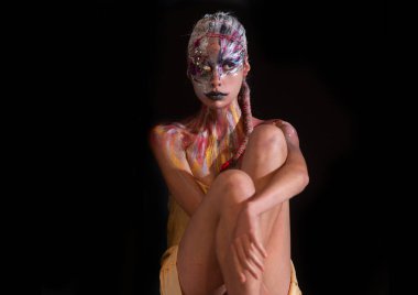Vücut sanatı. Yüz rengi tasarımı. Renkli güzel kadın yüzü. Yaratıcı sanat makyajlı güzel bir manken. Yaratıcı vücut sanatı ve saç modeli. Boyalı kadın. Çekici kadın yüz sanatı