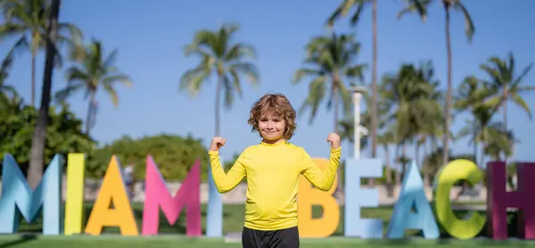 Chico Cerca Del Cartel Miami Beach Los Niños Disfrutan Vacaciones Fotos de stock libres de derechos