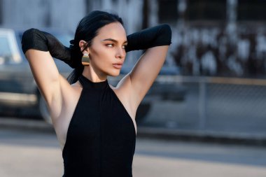 Sokakta poz veren güzel esmer kadın portresi. Genç ve güzel bir kızın yakın plan kadın portresi, yaz sokak modası. Açık havada zarif bir kadının yüksek moda portresi. Güzel surat.