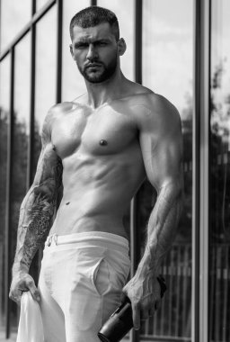 Spor salonunda kaslı adam egzersizi. Spor salonunda ağırlık çalışması yapan atletik bir adam. Spor salonunda güçlü kasları olan yakışıklı bir adam. Dambılı seksi kaslı erkek portresi. Vücut geliştirici egzersizi