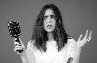 Saç dökülmesi sorunu olan bir kadın. Kel bir genç kızın portresi. Tedirgin bir kızın saç fırçasıyla kafasının fotoğrafı.