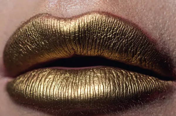 Lip with golden glitter effect. Woman mouth close up. Golden lipstick. Glamour luxury gold mouth. Gold paint on lips. Golden lips on woman mouth. Metallic body. Gold concept