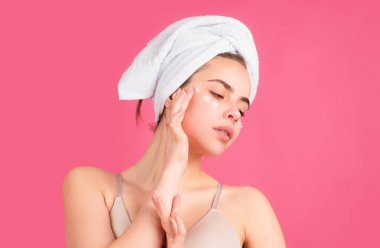 Genç bir kadın temiz tenli bir yüze dokunur. Yüz bakımı, banyo spa prosedürleri, pembe stüdyoda izole edilmiş. Sabah vakti, hijyen. Spa 'dan sonra. Güzellik tedavisinden sonra mükemmel cilde sahip güzel bir kadın