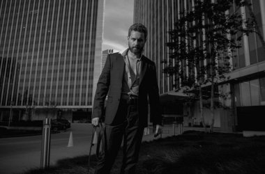 Takım elbiseli beyaz iş adamı ofisten çıkıyor. Son çalışma günü konsepti. Seksi moda işadamı