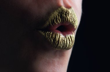 Öptüm. Seksi altın dudaklar, seksi dudaklarda altın ruj, metalik ağız. Şehvetli kadın ağzı. Seksi kız altın dudaklar, altın ağız. Parlak altın ten ve yaldızlı dudaklar. Metalik parlak altın dudak parlatıcısı
