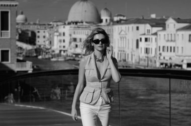 İtalya Venedik 'te yaz tatili. Avrupa 'nın Venedik caddesinde yürüyen şık, şık bir kadın. Venedik 'te moda yaz kıyafetleri giyen bir kadın. Venedik caddesinde poz veren seksi kadın.