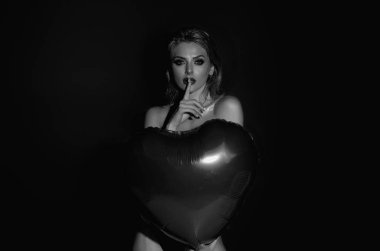 Güzel genç bir kadın elinde kırmızı kalp şeklinde balonlar, sevgililer günü. Seksi bir kadının romantik randevusu. Sevgililer Günü 'nü kutlayan kadın. Kırmızı balon kalpli güzel bir kadın portresi.