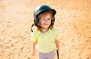 Komik çocuk beysbol oynuyor, göz kırpıyor. Gençler ligindeki vurucu vuruş yapıyor. Çocuk beyzbol topuna vuruyor.