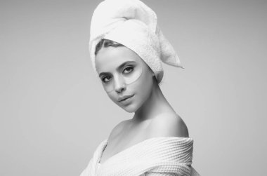 Kolajen hidrojel göz bantları, silikon bantlar. Göz altı nemlendirici bantlı cilt. Spa bakımı, kozmetoloji. Göz altı yamaları kullanan genç bir kadın.