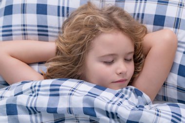 Tatlı uykular. Evde yatakta uyuyan tatlı bir çocuk. Yatma vakti, çocuk uyuyor. Çocuk battaniyeli yumuşak yastıkta uyuyor. Sağlıklı uyuyor.