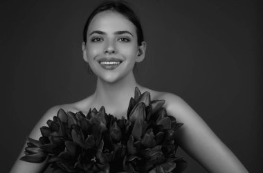 Romantik bir randevu ya da evlenme teklifi. Laleli güzel kız. Bir buket lale çiçeği. Güzel, şehvetli bir kadın lale buketi tutar, kırmızı arka planda stüdyo resmi.