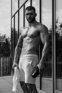 Yakışıklı adam antrenmana hazırlanıyor. Spor. Ağırlık çalışması. Spor salonunda vücut geliştirme egzersizi yapan bir adam. Spor, vücut geliştirme ve spor. Dambılla egzersiz yapan bir adam. Sıkı çalışma.