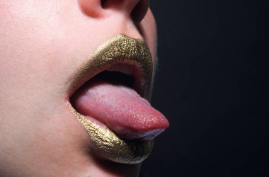 Altın parıltı efektli dudak simgesi. Şehvetli bir ağız. Altın rujdaki öpücüğün sembolü. Cazibeli altın ağızlı. Dudaklarında altın boya var. Altın dudaklar, şehvetli kadın ağzı. Metalik gövde. Altın kavram