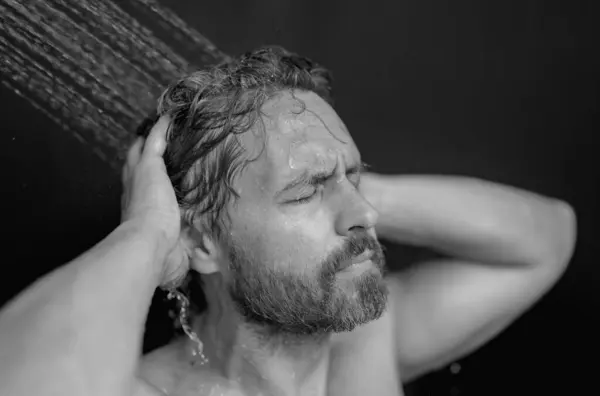 Portrait of man washing hair with shampoo taking shower. Washing hair with shampoo. Man washing hair with anti-dandruff shampoo, taking a shower. Hair care product, foam gel, shampoo and lotion