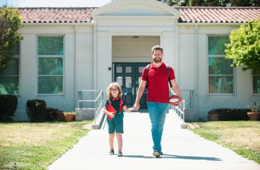 Baba oğlunu destekliyor ve motive ediyor. Çocuk ilkokula gidiyor.