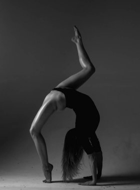 Esnek kız dansı. Güzel esnek kadın vücudu. Siyah üzerine seksi esnek bir kadının moda stüdyosu portresi. Jimnastik ince ve esnek dansçı kadın sahne alıyor. Esneme egzersizi
