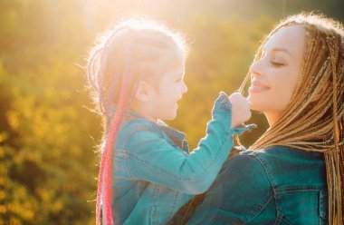 Mutlu anne kızına sarılıyor. Mutlu aile ve güzel anne-kız birlikte vakit geçiriyorlar. Anneler Günü. Aile tatili ve birliktelik