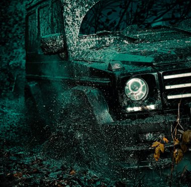 Off-road aracı dağ yolunda gidiyor. Alt manzaradan büyük off-road araba tekerine, şehir yolu ve dağ zemininde. Jeep açık hava maceraları. Dağların arasında bir kamyonet.