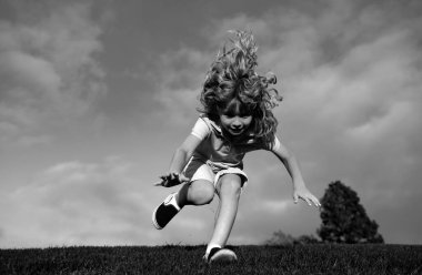 Çimlere düşen bir çocuk. Parkta düşen bir çocuk. Çocuk sigortası ve çocuk bakımı