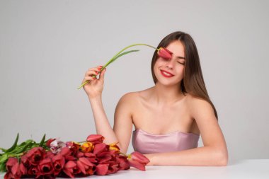 Laleli güzel kız. Güzel, şehvetli bir kadın. Lale buketi, stüdyo resmi.