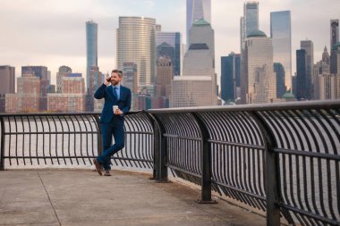 Şehir iş adamı dışarıda akıllı telefon kullanıyor. Takım elbiseli bir işadamı, Manhattan, New York 'taki uygulamalı mesajla cep telefonu kullanıyor. Amerikan iş konuşması